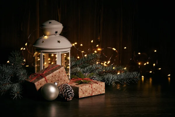 Різдвяний Натюрморт Гілками Ялинки Подарунковою Коробкою Прикрасами Лампою Темному Дерев — стокове фото