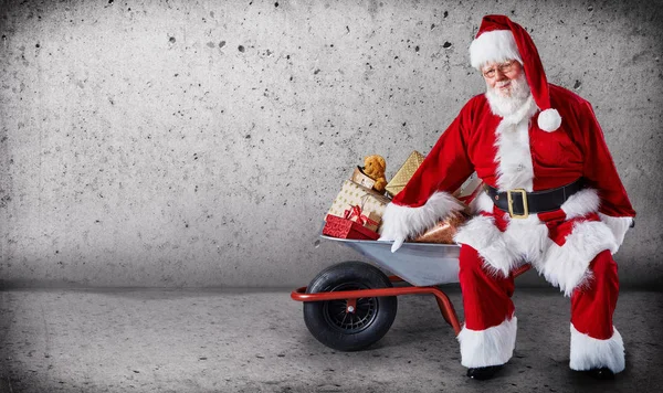 Papai Noel Com Carrinho Mão Cheio Presentes Natal Fundo Simples — Fotografia de Stock