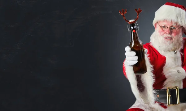 Święty Mikołaj Wznoszący Toast Świąteczny Butelką Piwa Ozdobioną Porogami Jelenia — Zdjęcie stockowe