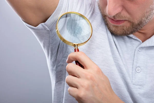 Nahaufnahme Eines Mannes Der Verschwitzte Achselhöhlen Durch Vergrößerungsglas Betrachtet — Stockfoto