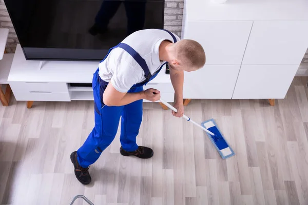 Lächelnder Männlicher Hausmeister Putzt Fußboden Mit Mopp Wohnzimmer — Stockfoto