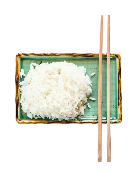 在白色背景查出的绿色盘子上的部分煮熟的米饭和筷子的顶部视图 — 图库照片