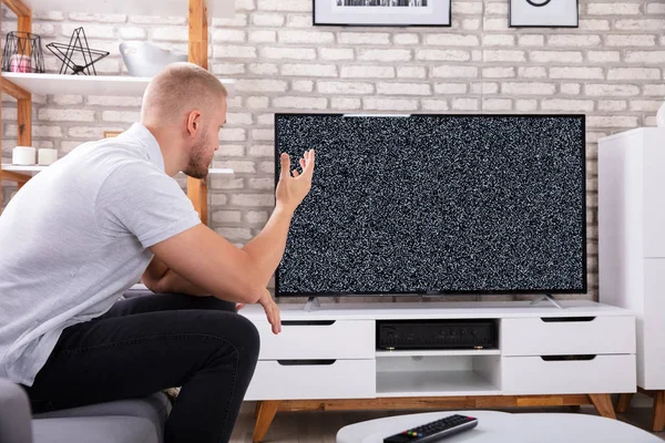 Frustrierter Junger Mann Sitzt Ohne Signal Auf Sofa Neben Fernseher — Stockfoto