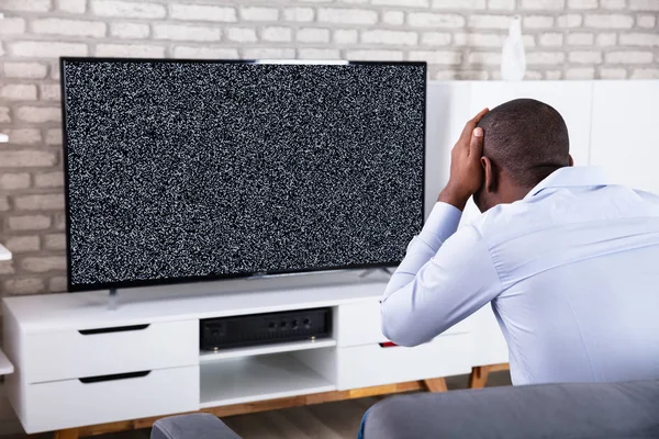 Afrikanischer Mann Berührt Seinen Kopf Der Nähe Des Fernsehens Und — Stockfoto