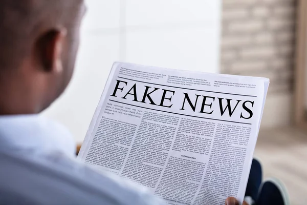 Närbild Afrikansk Man Läsa Falska Nyheter Tidningen — Stockfoto