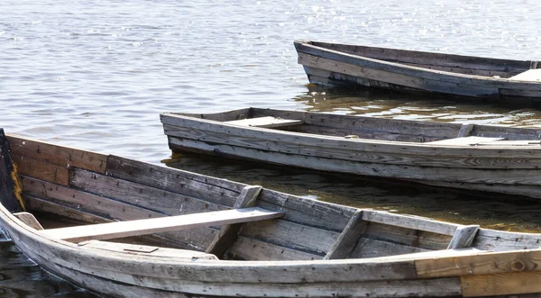 交通機関の一部である湖に浮かぶ古い木製のボートは地元の村の人口による漁業に使われています — ストック写真