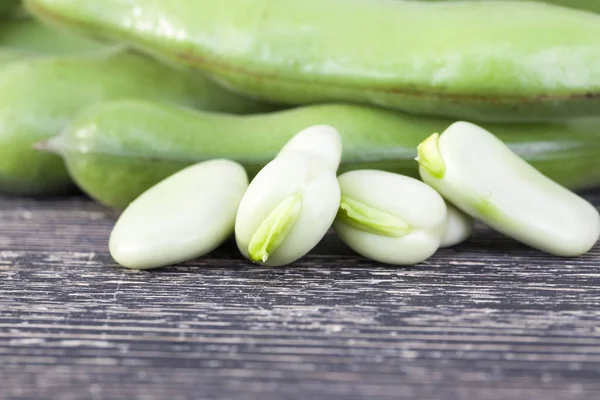 緑の新鮮な豆の穀物を木のテーブルに並べ — ストック写真
