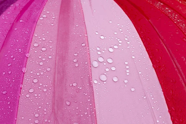 Красочный Зонтик Красным Цветом Оттенками Поверхности Которого Много Капель Воды — стоковое фото