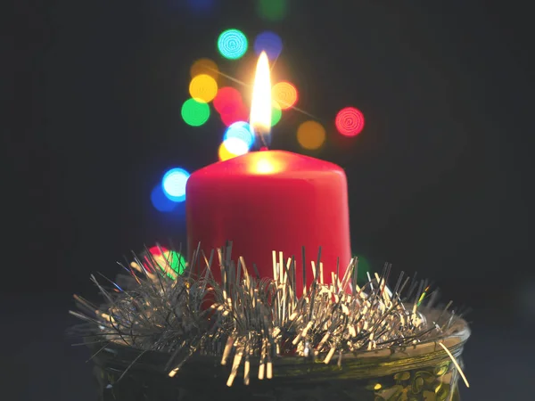 Uma Vela Vermelha Com Luzes Natal Borradas Fundo — Fotografia de Stock