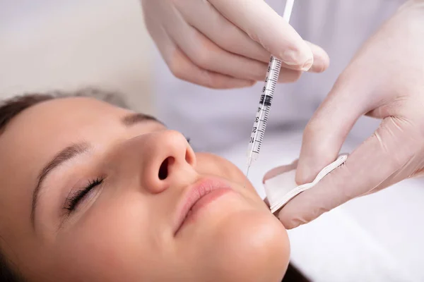 若い女性の顔に注射を与える医師の手のクローズ アップ — ストック写真