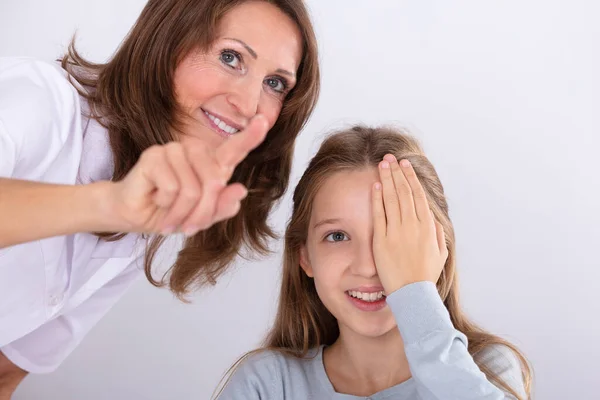 Sorrindo Optometrista Feminino Assistindo Menina Enquanto Verifica Visão Clínica — Fotografia de Stock