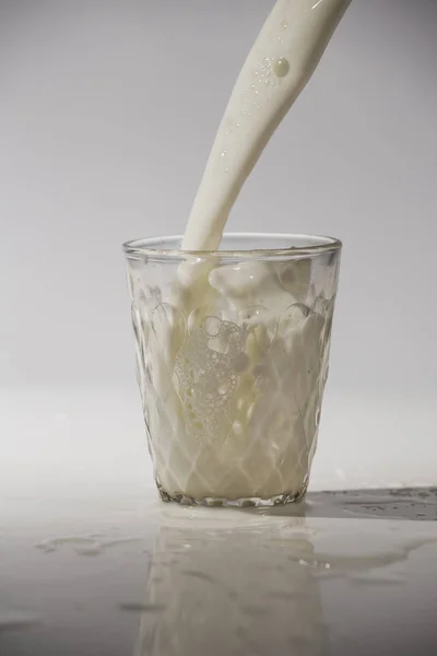 Kaatamalla Maitoa Valkoisella Pohjalla Eristettyyn Lasiin — kuvapankkivalokuva