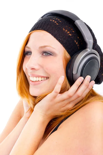 魅力的な若い女性がヘッドフォンで音楽を聴く — ストック写真