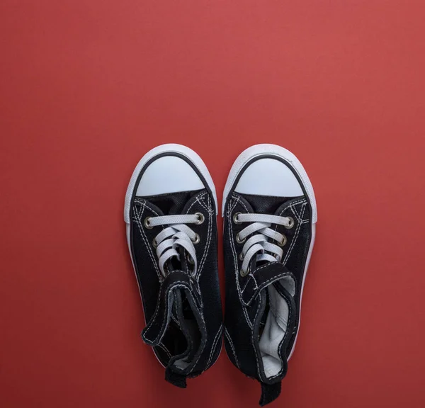 Sepasang Sepatu Bot Tekstil Hitam Tua Pada Latar Belakang Merah — Stok Foto