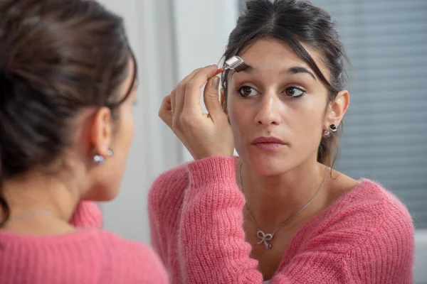 Μια Νεαρή Γυναίκα Μελαχρινή Που Βάζει Μακιγιάζ Στον Καθρέφτη — Φωτογραφία Αρχείου