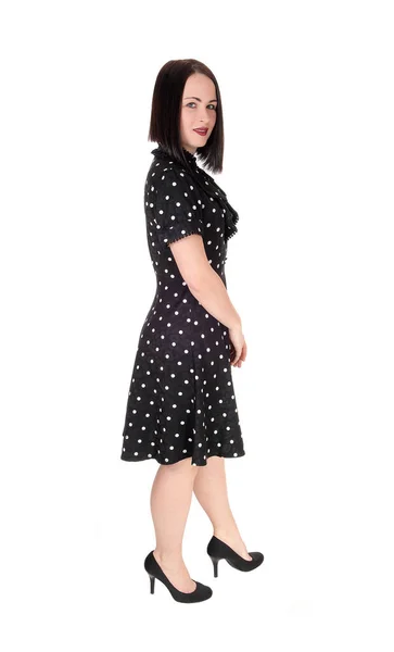 一位年轻貌美的女士站在一个灰色的小圆点上 穿着长裙和高跟鞋 短短的黑发 与白色背景隔离在一起 — 图库照片