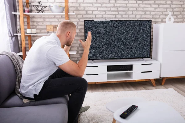 Frustrato Giovane Uomo Seduto Sul Divano Vicino Alla Televisione Senza — Foto Stock