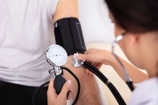 Close Doctor Measuring Blood Pressure Male Patient Stock Picture