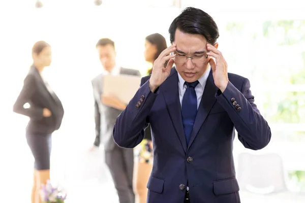 Portrait of Asian Businessman strain and got pressured after fail for his work in cafe with business team in background using for coporate background work