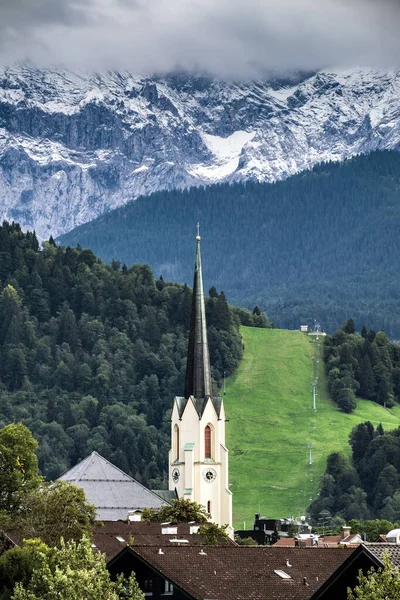 在秋天以森林和山脉到 Garmisch Partenkirchen 的教堂的看法 — 图库照片
