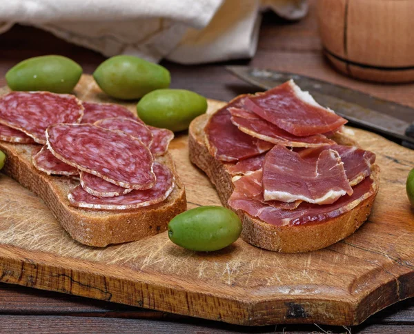 Sanduíches Com Salsicha Fumada Salame Jamon Uma Placa Cozinha Madeira — Fotografia de Stock