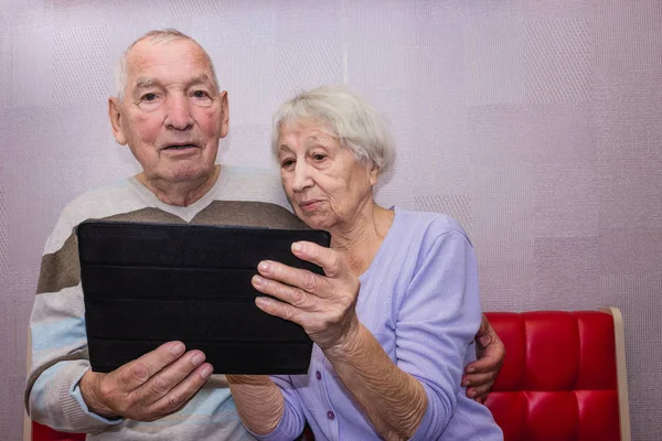 Senioren Verrast Paar Met Tablet Ontspannen Thuis — Stockfoto