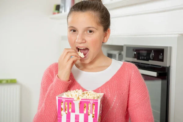 Junges Teenager Mädchen Mit Rosa Pullover Das Hause Popcorn Isst — Stockfoto