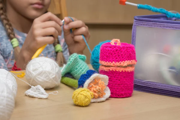 stock image Childrens crafts-embroidery lying on the table, in the background the girl knits