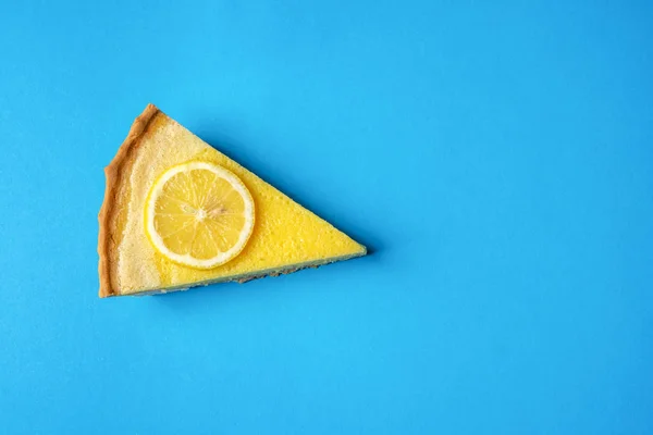 Кусок Желтого Лимонного Торта Украшенный Ломтиком Лимона Синем Фоне Прямо — стоковое фото