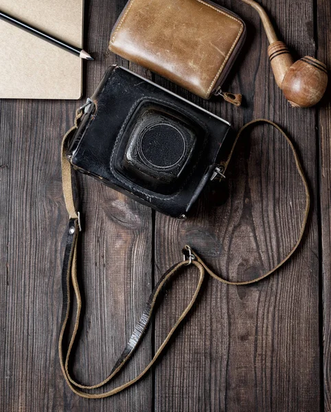 old vintage camera in a case on a wooden background, top view