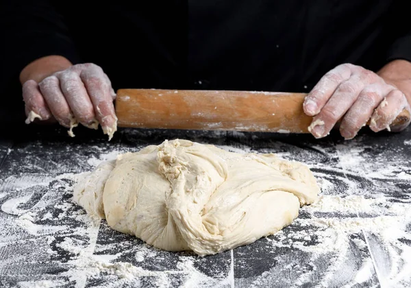 白い小麦粉の丸い生地と男性の手に木製の麺棒 — ストック写真