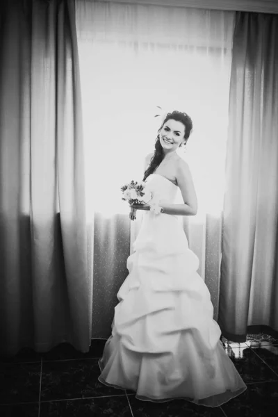 Black white photography beautiful young happy bride standing near the window