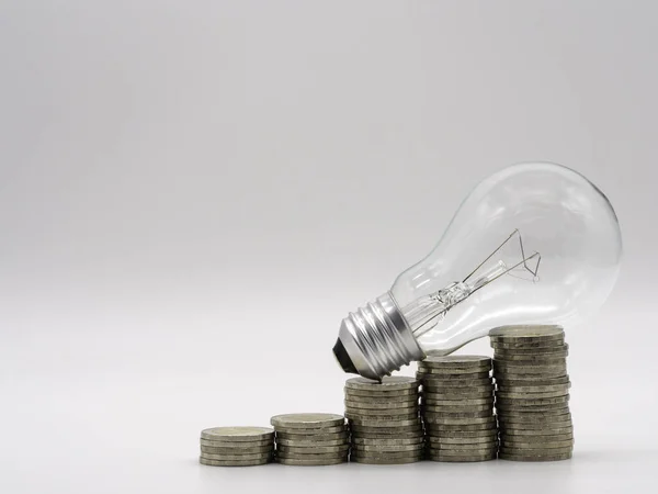 Energy saving light bulb with stacks of coins for financial, accounting and saving concept.