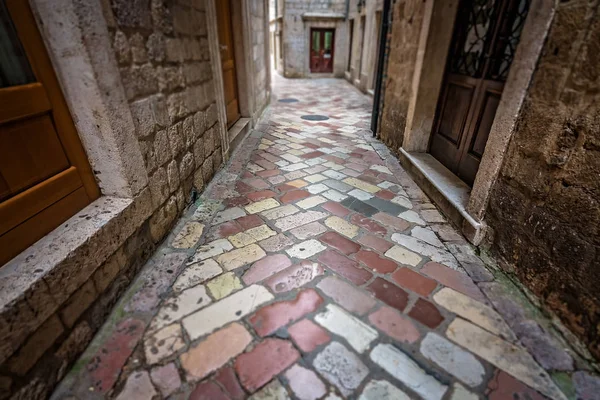Kotor 老城的历史居民楼之间狭窄的鹅卵石石墙通道 — 图库照片
