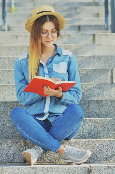 Una Joven Estudiante Vestida Con Sombrero Una Camisa Mezclilla Escribe — Foto de Stock