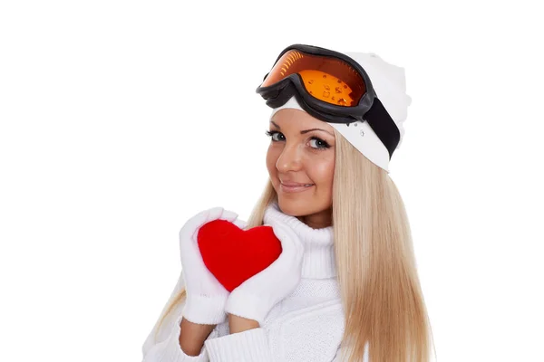 身穿冬衣 戴着滑雪眼镜的年轻女子手牵着一颗红心 背景是白色的 — 图库照片