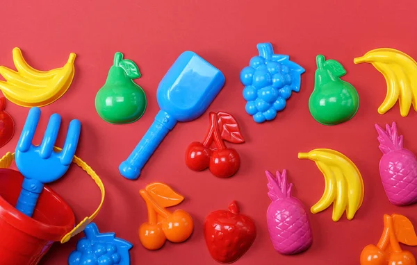 Giocattoli Bambini Plastica Sotto Forma Frutta Secchio Uno Sfondo Rosso — Foto Stock