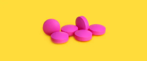 Kilka Dużych Różowe Tabletki Rozrzucone Żółtym Tle — Zdjęcie stockowe