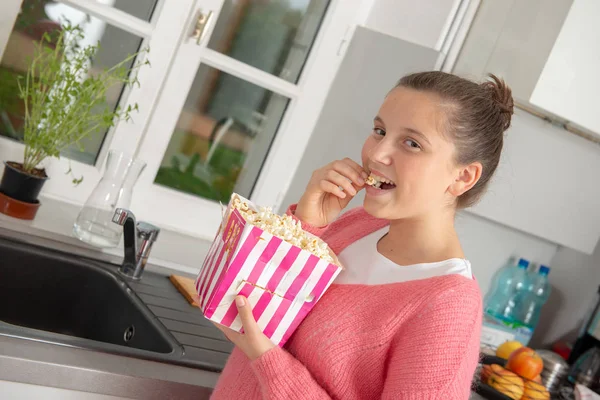 Junges Teenager Mädchen Mit Rosa Pullover Das Hause Popcorn Isst — Stockfoto