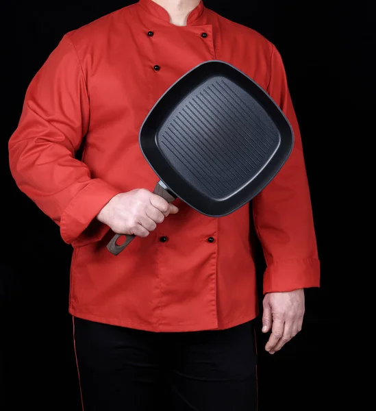 Cocinar Uniforme Rojo Sosteniendo Una Sartén Negra Cuadrada Vacía Fondo —  Fotos de Stock