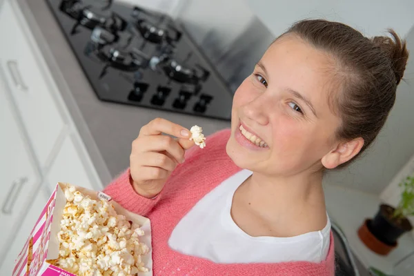Junges Teenager Mädchen Mit Rosa Pullover Das Hause Popcorn Isst — Stockfoto