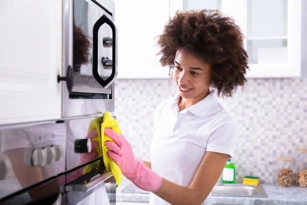 Close Uma Empregada Limpeza Forno Sorridente Feminino Com Guardanapo Amarelo — Fotografia de Stock