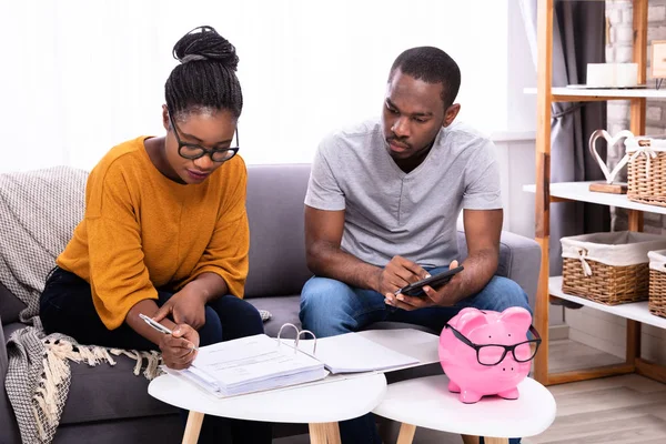 Young African Couple Sitting Sofa Calculating Invoice — Stock Photo, Image