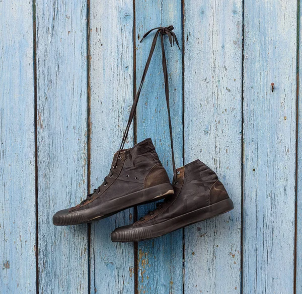 Bir Mavi Ahşap Duvarda Asılı Siyah Tekstil Ayakkabı — Stok fotoğraf