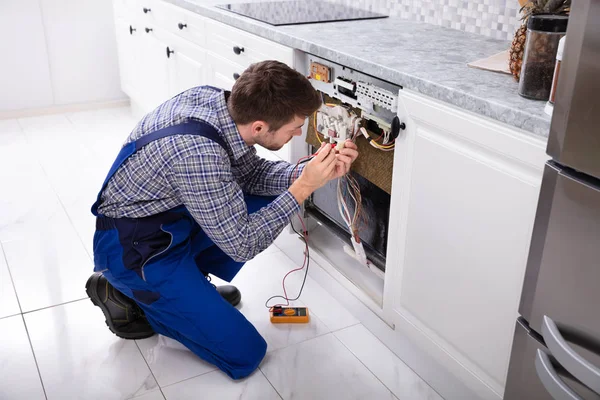 Jovem Reparador Fixando Máquina Lavar Louça Com Multímetro Digital Cozinha — Fotografia de Stock