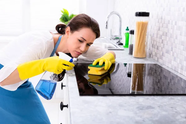 Jovem Mulher Limpeza Indução Fogão Com Esponja Cozinha — Fotografia de Stock