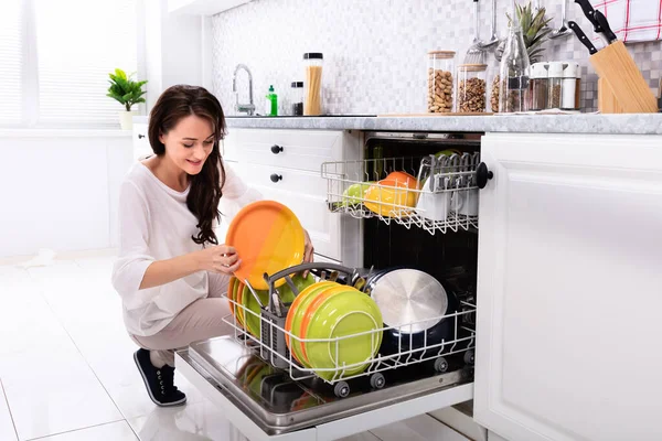 Smiling Young Woman Arranging Plates Dishwasher Home — Stock Photo, Image