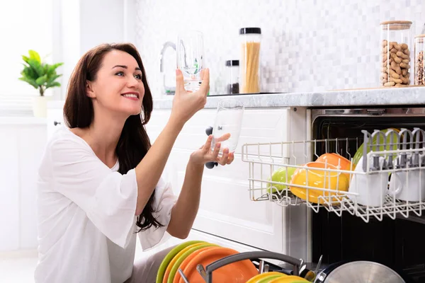 Mujer Joven Feliz Mirando Vasos Beber Cerca Del Lavavajillas — Foto de Stock