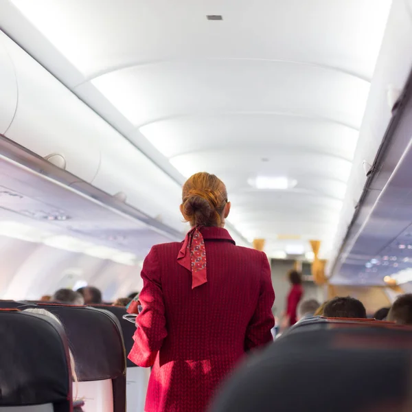 Stewardess Roter Uniform Geht Durch Den Gang Eines Verkehrsflugzeugs Unerkennbare — Stockfoto