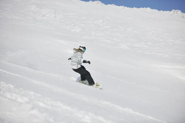 下り坂を駆け抜け 冬と晴れた日にはパウダースノーに乗り込むスノーボード女子 — ストック写真